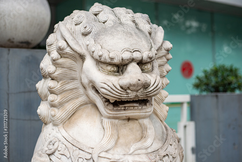 Statue of a Chinese dragon. Head of a lion from white marble, grin teeth © Alexander