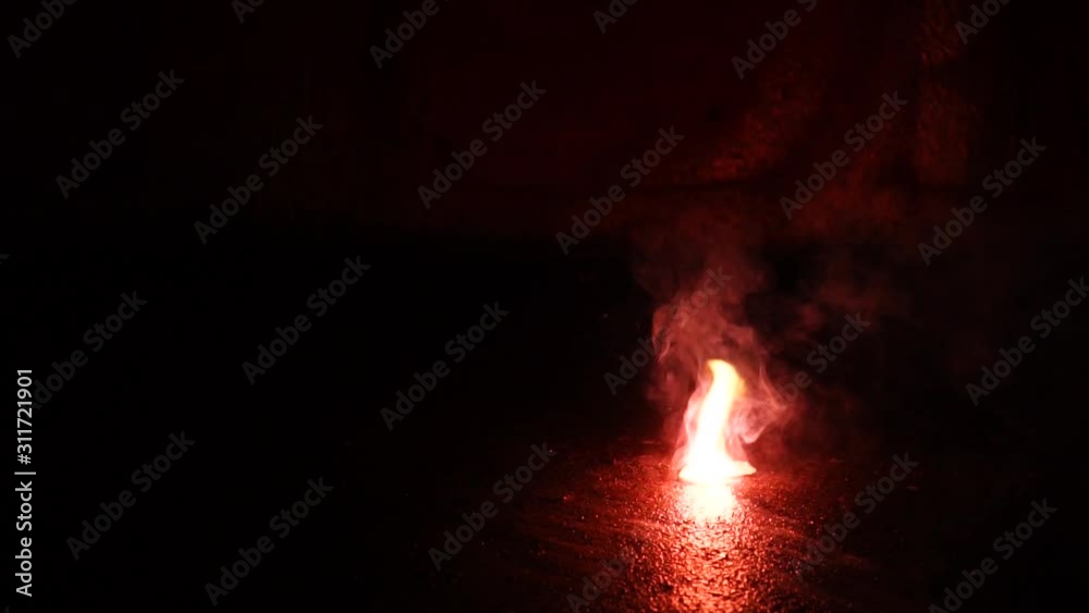 Red firework crackling, exploding and jumping on the ground in front of ...