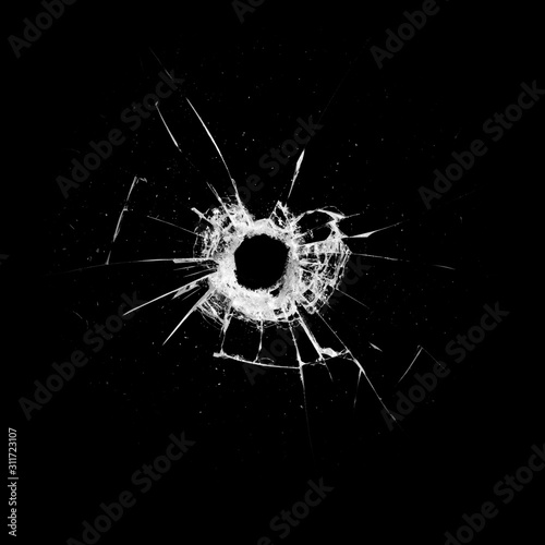 glass with a hole and cracks isolated on a black background photo