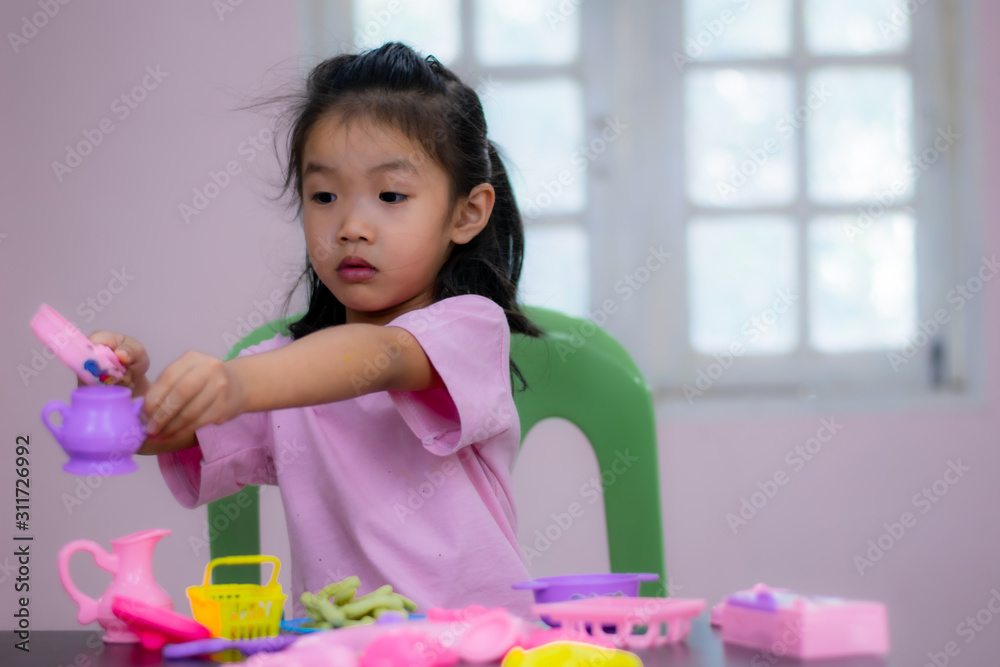 Kindergarten children in Asia are playing toys on the table.