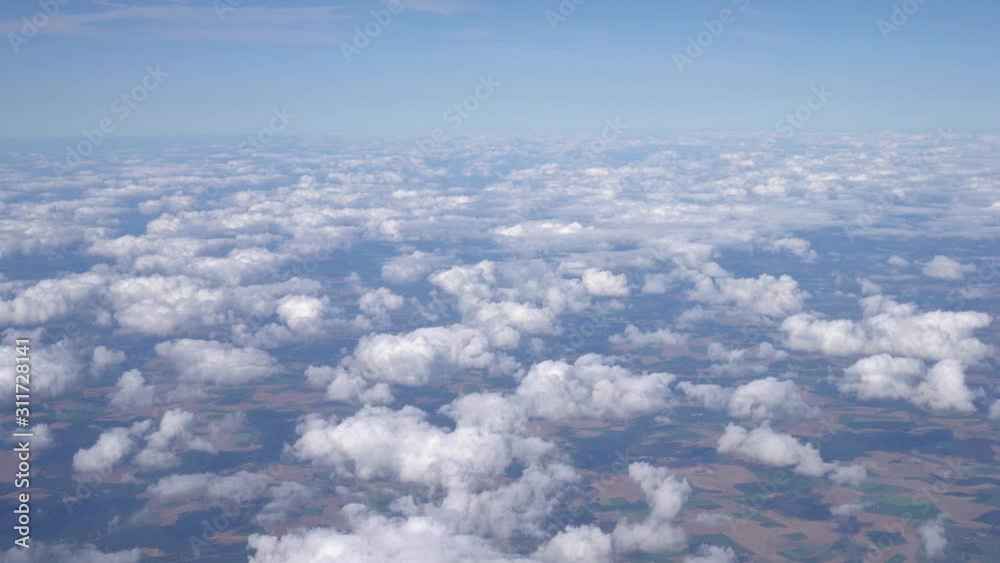 Panoramic view from the airplane window. Flying over beautiful clouds that extend to the horizon. Gently blue sky in the background. Ultra HD stock footage Panoramic view from the airplane window. Flying over beautiful clouds that extend to the horizon. Gently blue sky in the background. Ultra HD stock footage