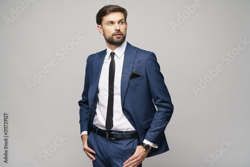 studio photo of young handsome businessman wearing suit
