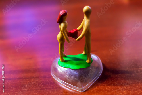plasticine man and woman give each other a heart