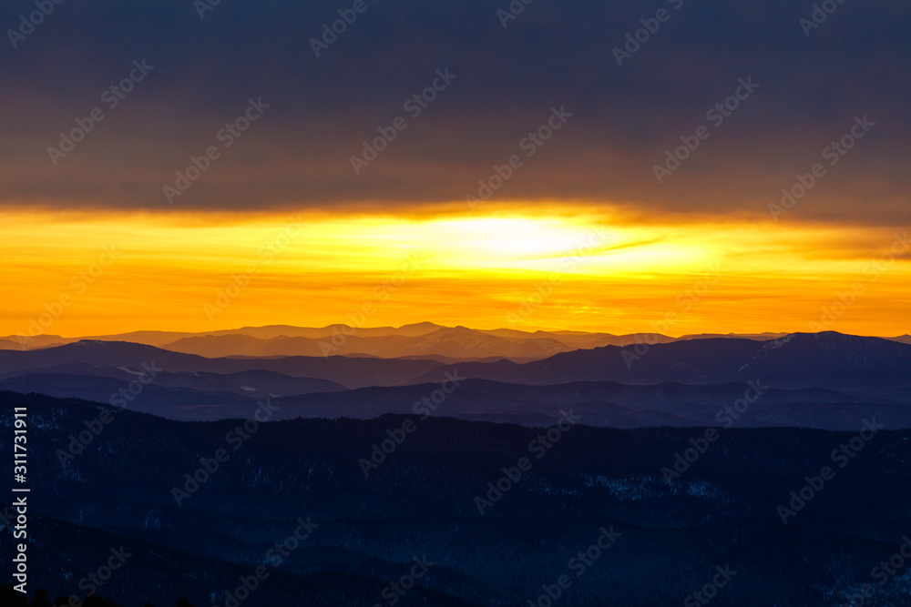 Golden sunrise in a mountain valley with beautiful contours of dark blue outlines of the highlands. landscape with a mountain landscape horizon in the style of the artist 