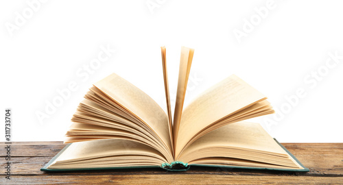Open book on wooden table against white background