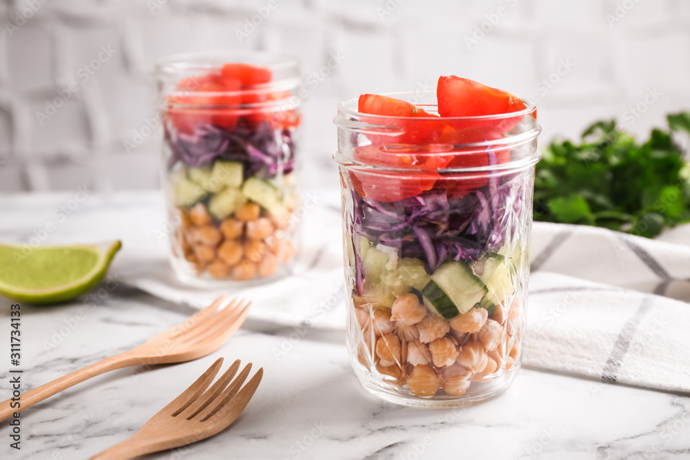Healthy salad in glass jars on marble table Healthy salad in glass jars on marble table