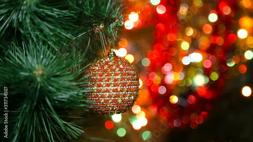 Christmas toy on a Christmas tree against a garland in the blur