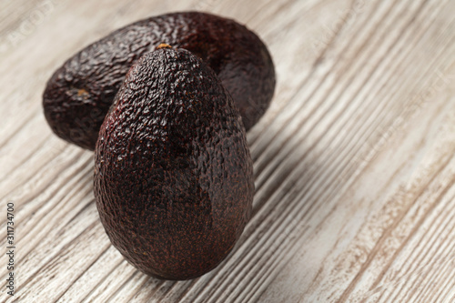 Avocado - dark hass avocado on wooden board © 8H