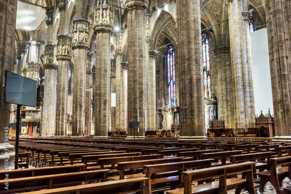 Obraz premium Interiors of building with columns and benches of the Milan Cathedral (Duomo di Milano), the cathedral church of Milan, Lombardy, Italy. Dedicated to the Nativity of St Mary.