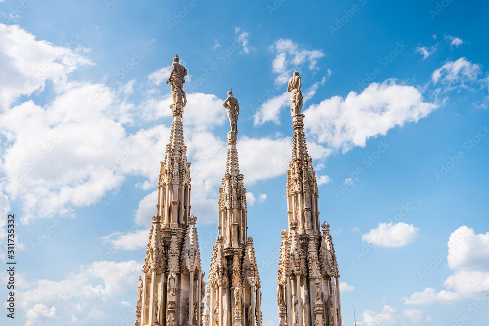 Architectural details with statues on the top of beautiful building of the Milan Cathedral (Duomo di Milano), the cathedral church of Milan, Lombardy, Italy. Dedicated to the Nativity of St Mary. Architectural details with statues on the top of beautiful building of the Milan Cathedral (Duomo di Milano), the cathedral church of Milan, Lombardy, Italy. Dedicated to the Nativity of St Mary.