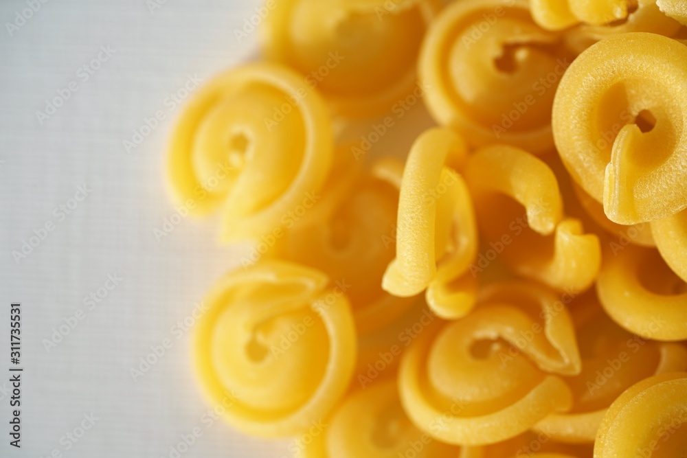 Top view on Italian messicani pasta shapes on white background Top view on Italian messicani pasta shapes on white background