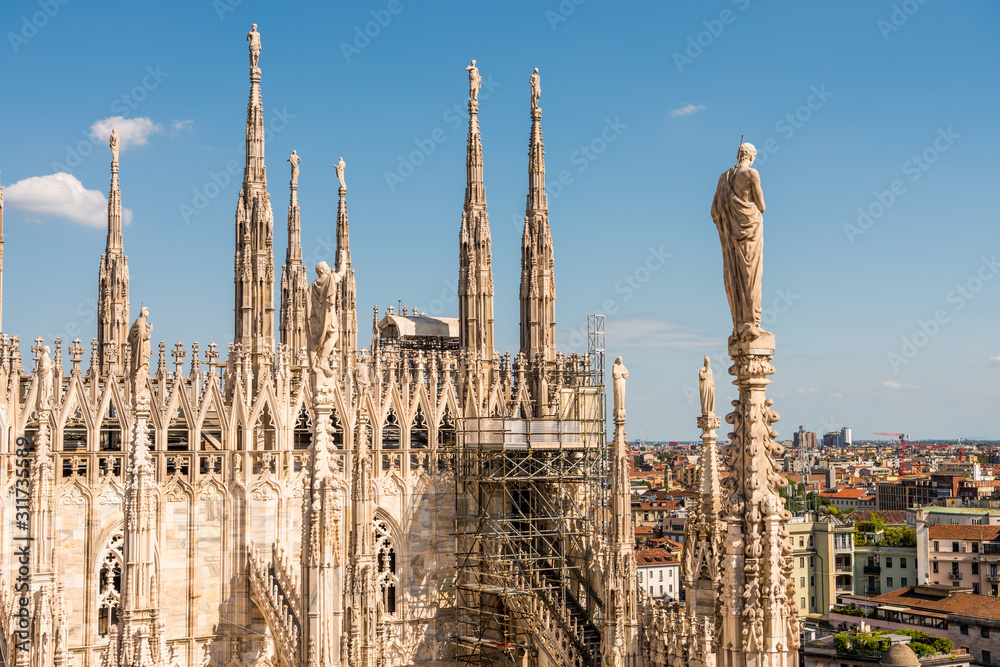 Architectural details with statues on the top of beautiful building of the Milan Cathedral (Duomo di Milano), the cathedral church of Milan, Lombardy, Italy. Dedicated to the Nativity of St Mary.