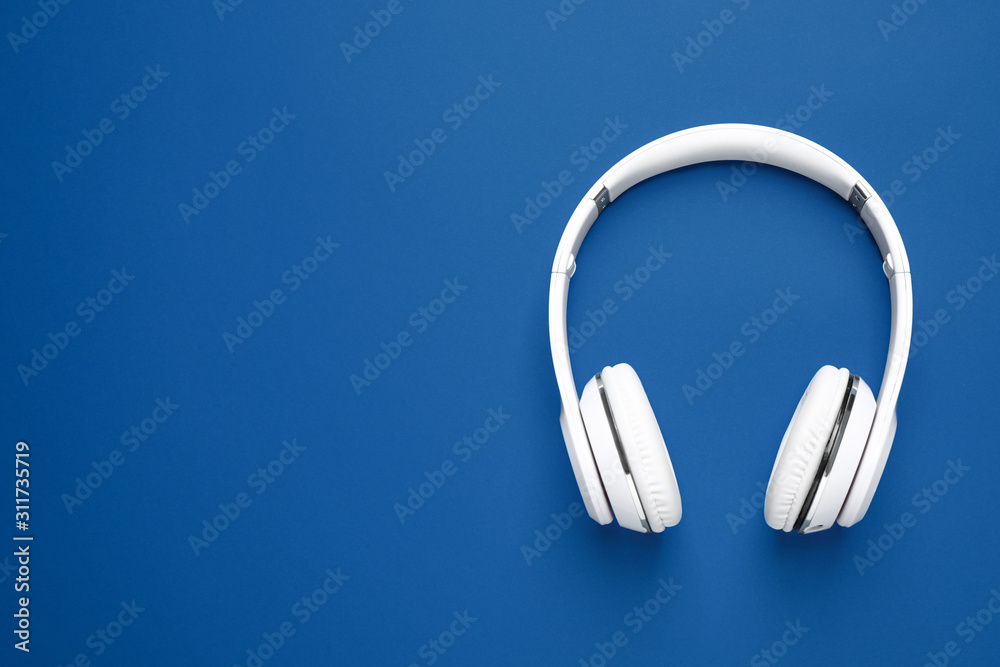 Headphones on bright background, top view with space for text. Color of the year 2020 (Classic blue) Headphones on bright background, top view with space for text. Color of the year 2020 (Classic blue)