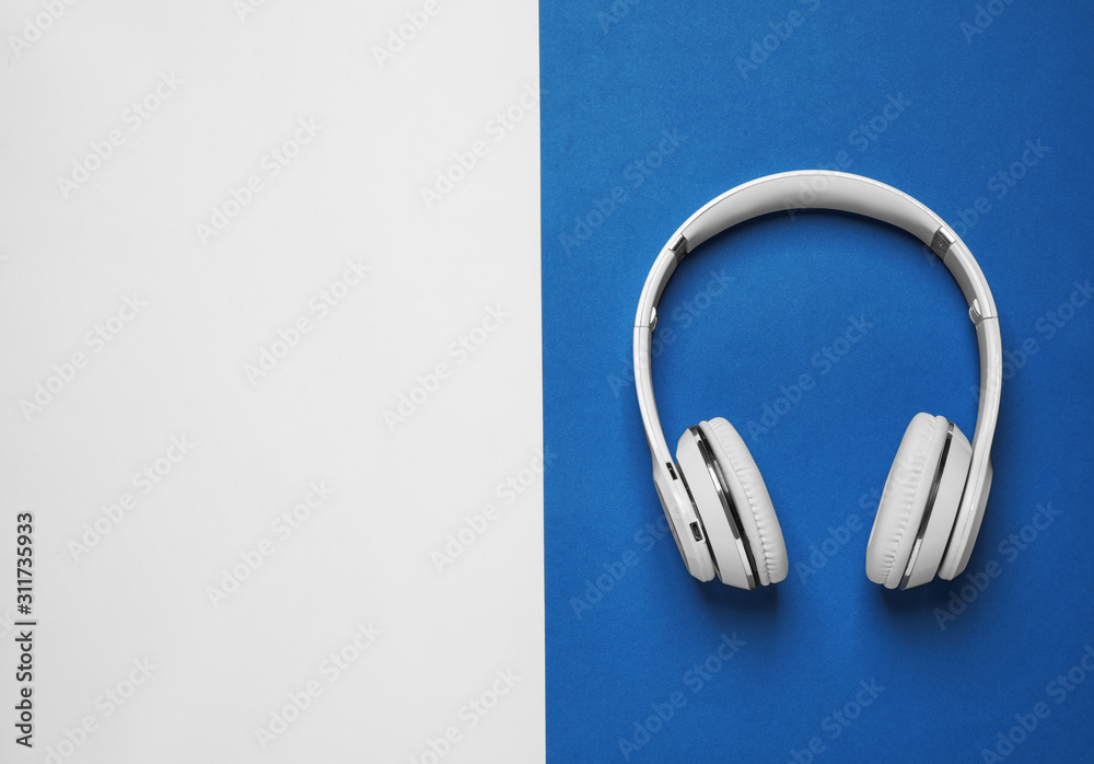 Headphones on bright background, top view with space for text. Color of the year 2020 (Classic blue) Headphones on bright background, top view with space for text. Color of the year 2020 (Classic blue)