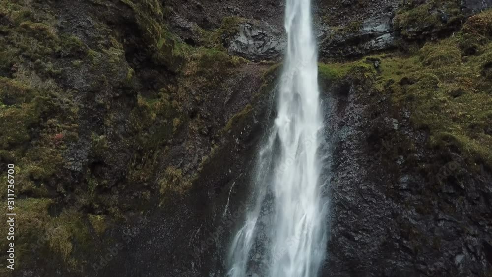 Fresh Glacial Water Falls Over Rugged Volcanic Cliff in Highland of Iceland, Close Up Aerial. Waterfall in Pristine Icelandic Nature Fresh Glacial Water Falls Over Rugged Volcanic Cliff in Highland of Iceland, Close Up Aerial. Waterfall in Pristine Icelandic Nature
