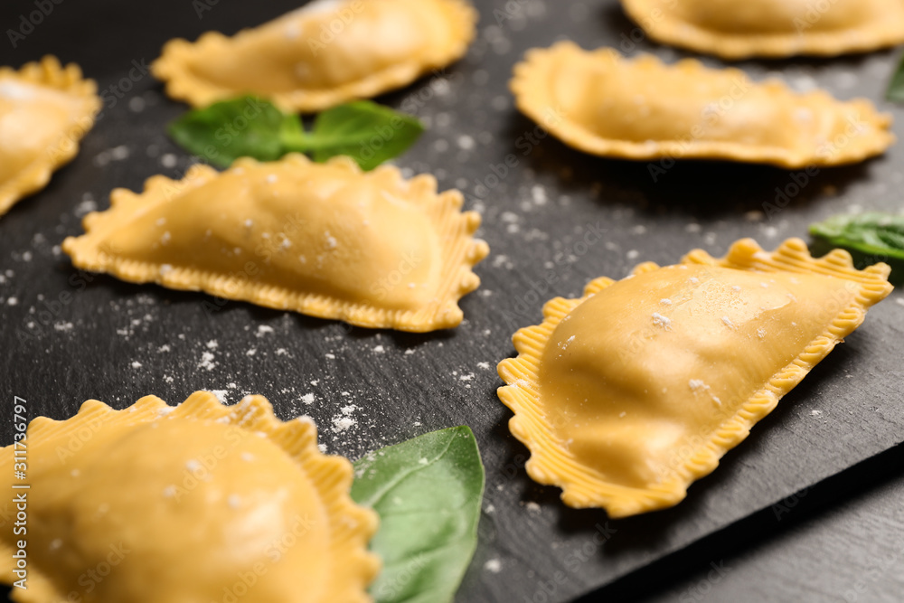 Raw ravioli with basil on black table, closeup. Italian pasta Raw ravioli with basil on black table, closeup. Italian pasta