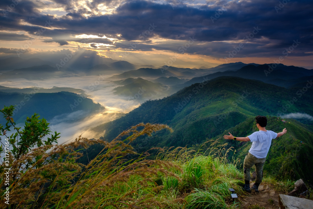 Fototapeta premium A man standing on top of the mountain view in the morning in Lerkwador, Tak province, Thailand
