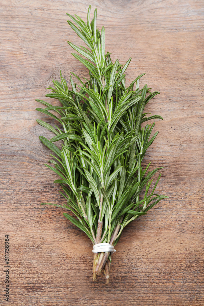 Bunch of fresh rosemary on wooden table, top view Bunch of fresh rosemary on wooden table, top view