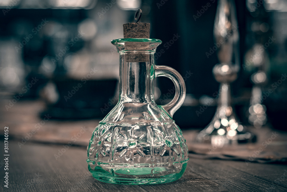 Glass transparent carafe with cork on served table. Front view. Glass transparent carafe with cork on served table. Front view.