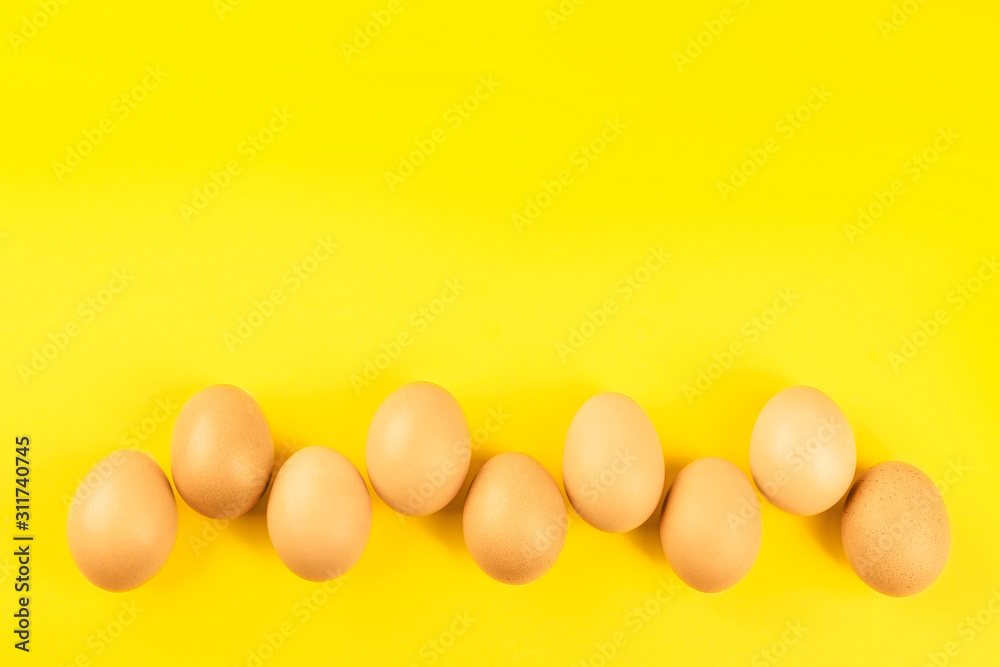 Raw chicken eggs on yellow background, flat lay. Space for text Raw chicken eggs on yellow background, flat lay. Space for text
