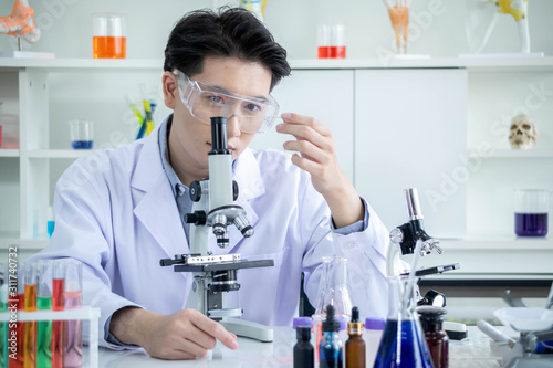 concept of medical, chemicals or scientific laboratory research and Innovation in the laboratory. experienced handsome Asian man scientist is performing work in the laboratory.