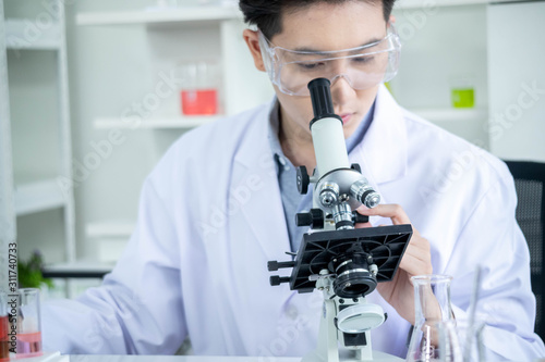 concept of medical, chemicals or scientific laboratory research and Innovation in the laboratory. experienced handsome Asian man scientist is performing work in the laboratory.