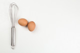 Raw eggs and whisk on white background, top view with space for text. Baking pie