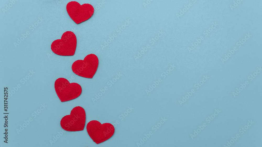 Concept for valentines day. Red hearts on a blue background