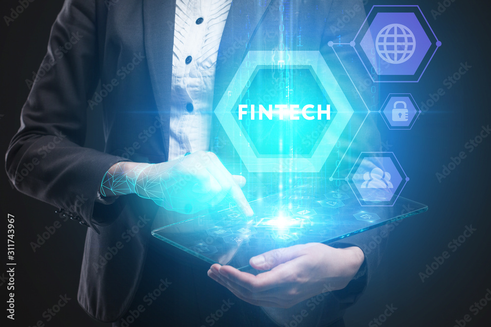 Business, Technology, Internet and network concept. Young businessman working on a virtual screen of the future and sees the inscription: Fintech Business, Technology, Internet and network concept. Young businessman working on a virtual screen of the future and sees the inscription: Fintech
