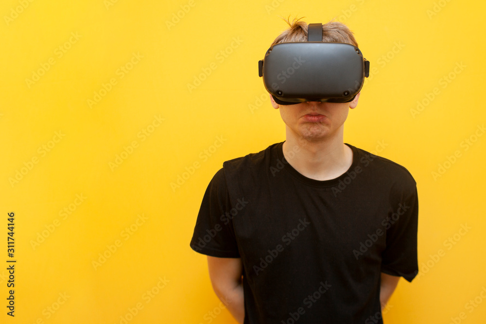 sad guy with VR glasses on a yellow background, using modern virtual reality gadgets sad guy with VR glasses on a yellow background, using modern virtual reality gadgets