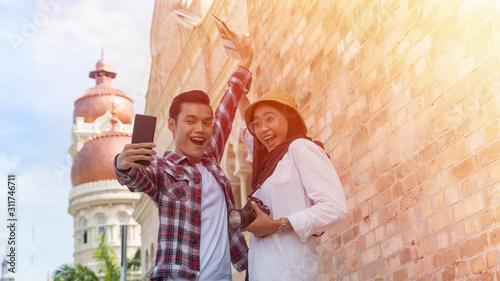 Canvas Print Muslim Tourist Couple at Kuala Lumpur taking selfie