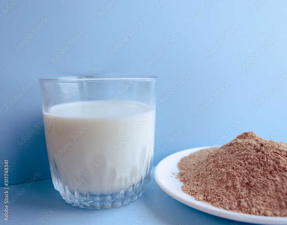 Natural organic Ingredients for making a cake, biscuit, pie, cookies, flour cacao and milk on a blue background. homemade with copy space. Flat lay. Natural organic Ingredients for making a cake, biscuit, pie, cookies, flour cacao and milk on a blue background. homemade with copy space. Flat lay.