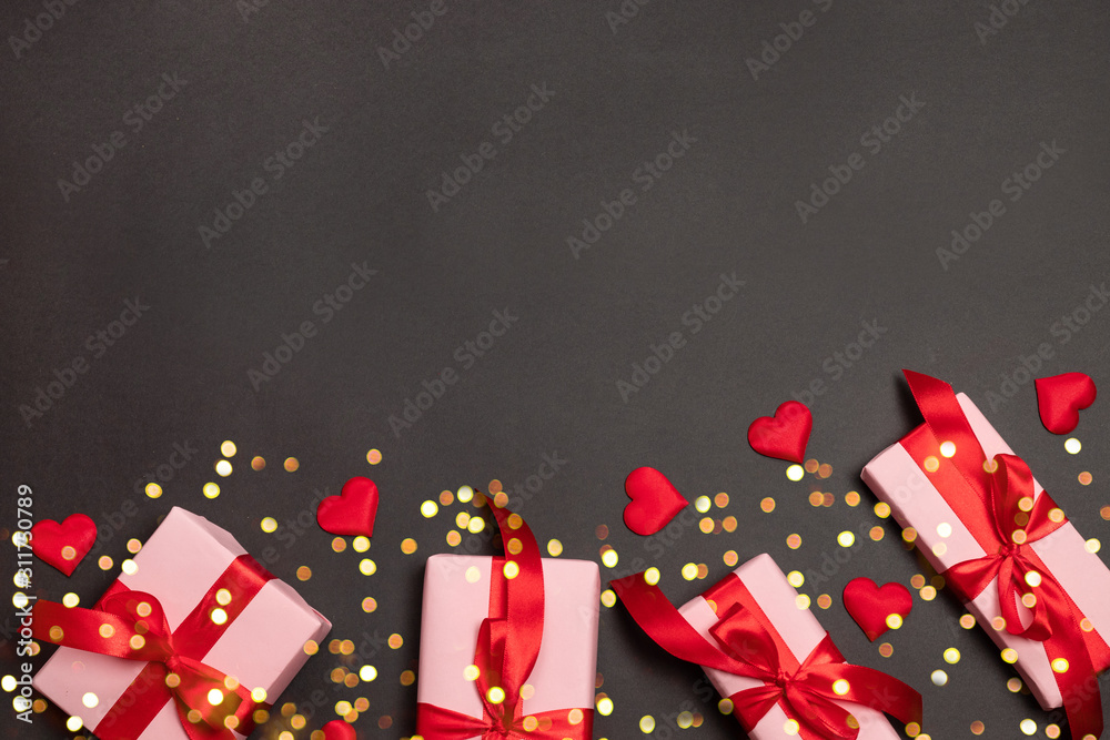 Valentine's day background with surprise gift and gold ribbons, red love shape on dark background. Flat lay, top view