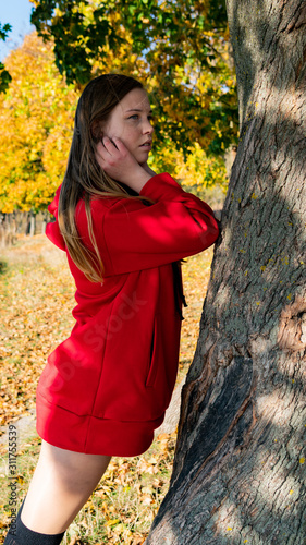 Incredible stunning girl in a red dress. The background is fantastic autumn. Artistic photography.