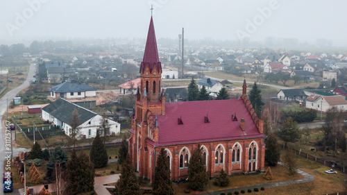 Aerial view neogothic red catholic church of the Heart Jesus in small Belarusian village Stolovichi. photo