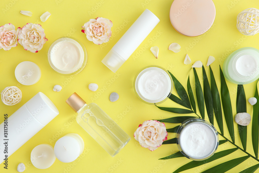 Care cream and flowers on a colored background top view. Skin care cosmetics. Care cream and flowers on a colored background top view. Skin care cosmetics.