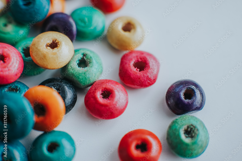 colorful wooden beads on a white table colorful wooden beads on a white table