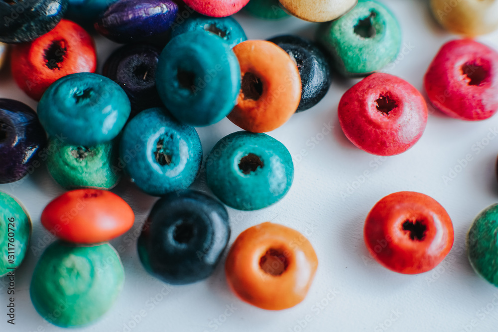 colorful wooden beads on a white table colorful wooden beads on a white table