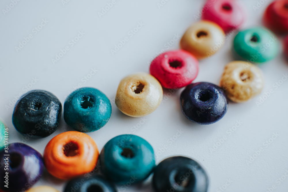 colorful wooden beads on a white table with copyspace colorful wooden beads on a white table with copyspace