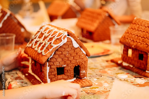 cooking gingerbread cookies, a house of cookies for Santa, kids are preparing to eat, decorating the house