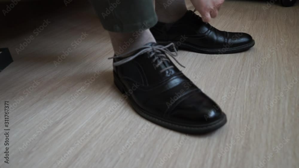 the man puts on his shoes and laces them the man puts on his shoes and laces them