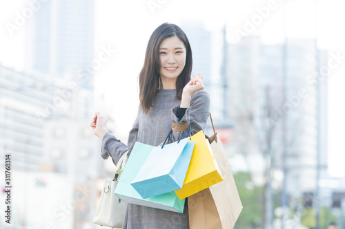 たくさんの買い物袋を抱える女性