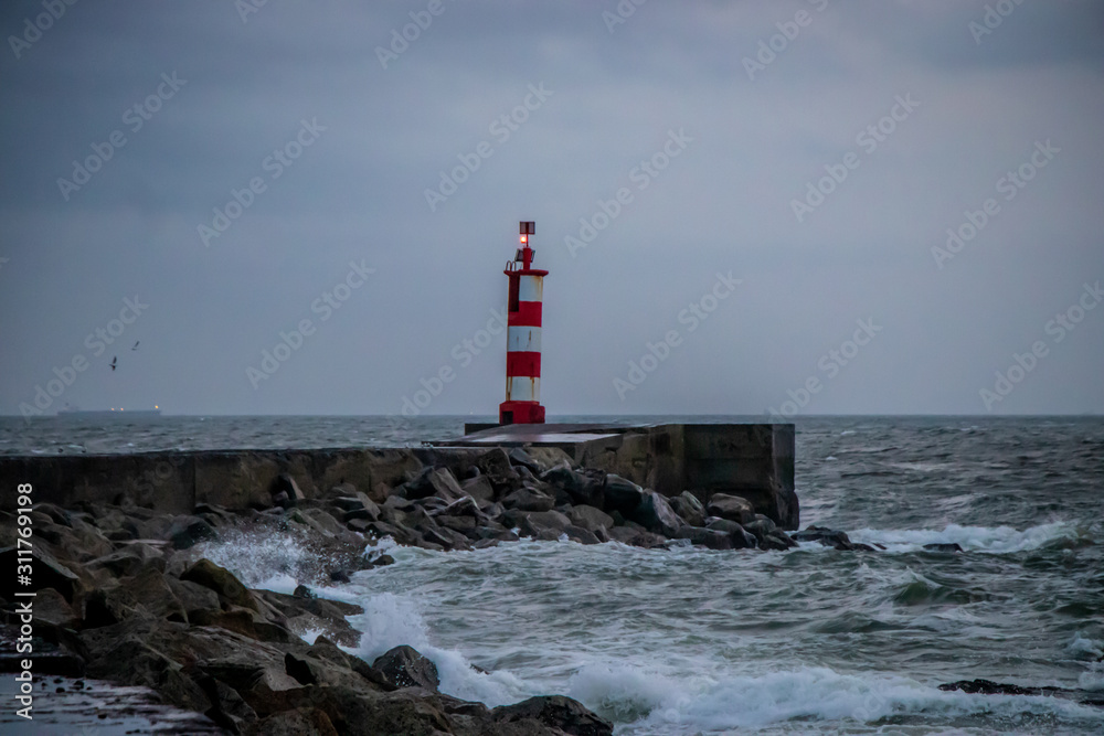 View to a lighthouse in a cloudy winter day