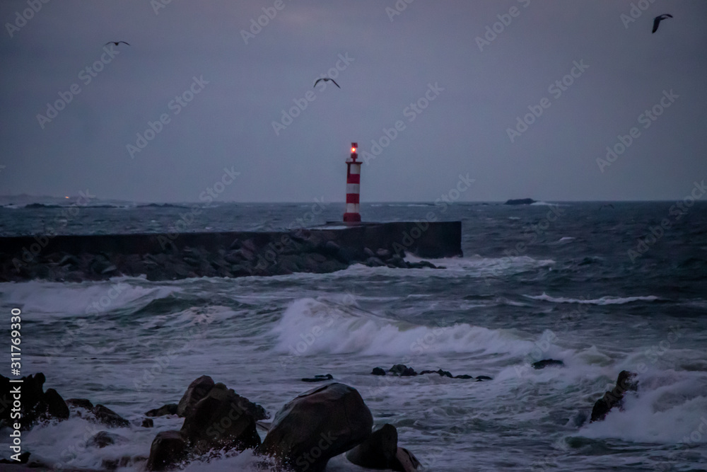 View to a lighthouse in a cloudy winter day