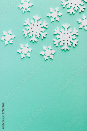 Christmas background for text or design. Wooden snowflakes on a blue background. Popular color 2020 year. Wooden white snowflakes of different sizes.