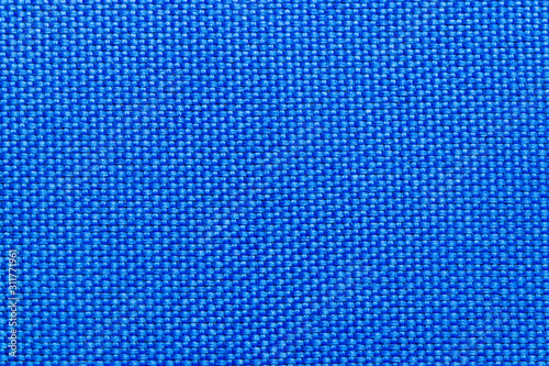 Close-up of blue nylon fabric background texture. Sturdy woven fabric for sports equipment or backpacks. Macro photograph.