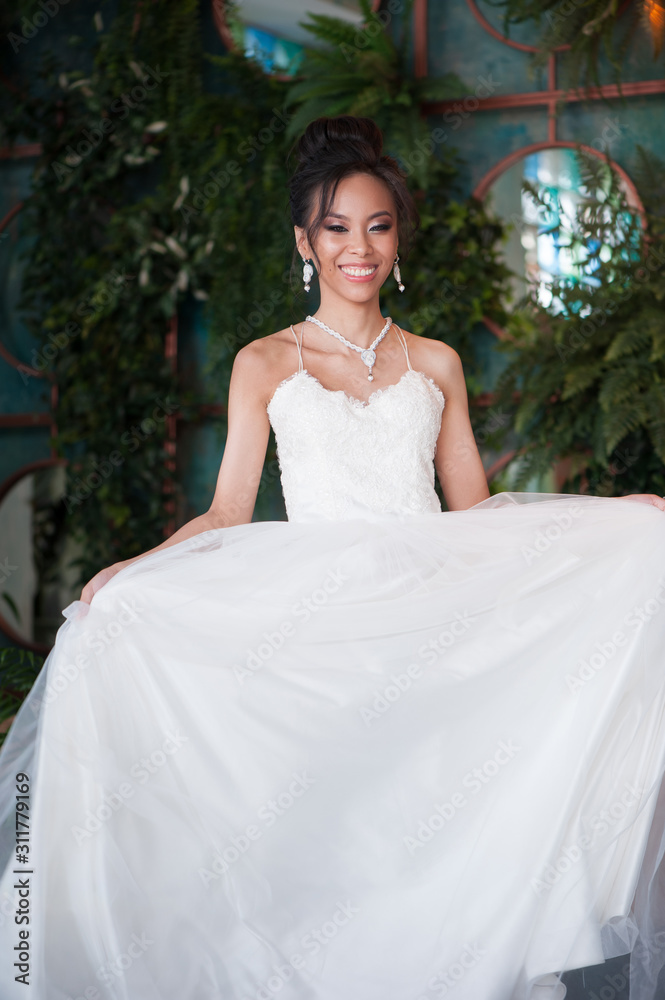 Beautiful asian bride showing her bridal white dress