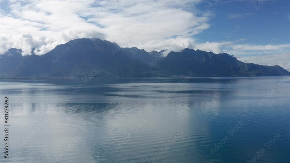 Rising shot from Lake Geneva Switzerland. View to French mountains. Straight view to Evian-les-Bains. Place where Evian mineral water coming from. Cloudy day Rising shot from Lake Geneva Switzerland. View to French mountains. Straight view to Evian-les-Bains. Place where Evian mineral water coming from. Cloudy day