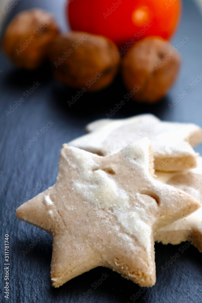 christmas baked stars with closed nuts and orange on a dark grey slate christmas baked stars with closed nuts and orange on a dark grey slate
