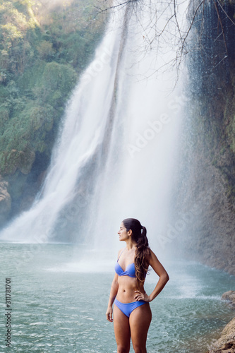 tourist woman in swimming suit at Thi Lo Su Waterfall in National Park in Thailand. Deep Forest beautiful nature scenery. Travel and holidays concept. Trekking and rafting in Asia. Exotic tourism.